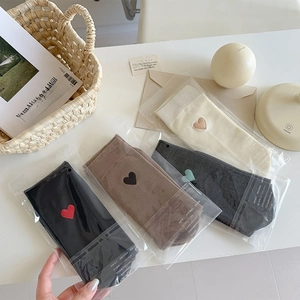 Detailed view of four-color cotton socks with heart embroidery in premium packaging