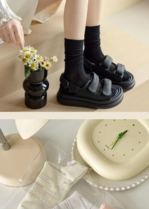 Detail showing black cotton mid-calf socks paired with sandals and premium packaging