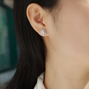 Sterling silver oval cut stud earrings with halo diamonds on female model
