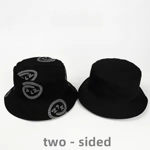 Two-sided reversible black cotton bucket hat with abstract smiley print for sun protection