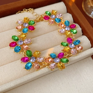 Detail of vintage gold bracelet with colorful oval gemstones in a beige velvet jewelry box