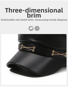 Detail of black leather beret featuring a golden chain decoration and metallic eyelets