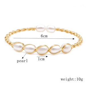 Detail of woven gold bracelet with 6cm diameter, white pearls and 10g weight specs
