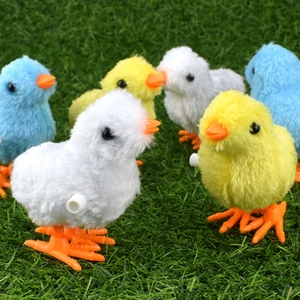 Close-up of colorful plush wind-up chicks on green grass featuring detailed fur and gears