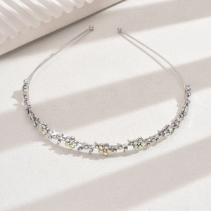 Detailed view of silver metal headband with iridescent rhinestones in flower shapes