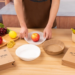 Close-up of 16x4.5cm round air fryer paper liners in white and natural wood colors