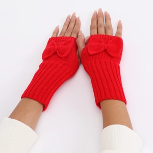 Detail of red knit fingerless gloves with a decorative bow and soft ribbed cuffs