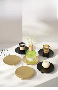 Detail of Nordic round candle holders with matte gold and black finish and ball feet