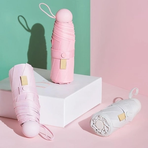 Three ultra-light pink, purple, and white capsule umbrellas in a compact folded design