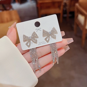 Detailed close-up of 925 silver needle bow earrings with sparkling crystal tassels