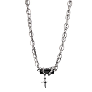 Macro view of silver layered chain with black stone pendant and silver cross charm