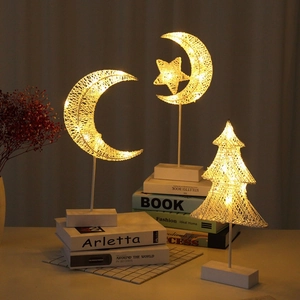 Star and moon LED decorative bedside lamps with warm yellow glow on books