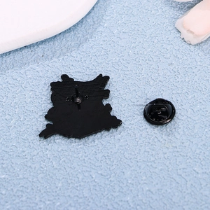 Cartoon enamel pin back view showing metal needle and black rubber clutch accessory
