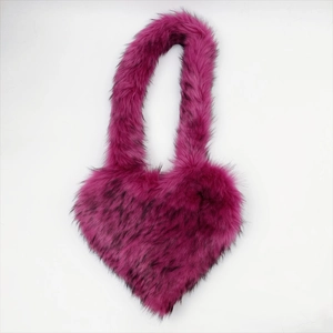 Macro detail of plush heart-shaped faux fur shell bag in vibrant magenta and black tips