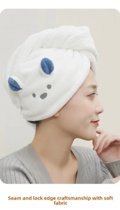 Detail of reinforced edge stitching and soft coral fleece texture on rabbit ear hair towel