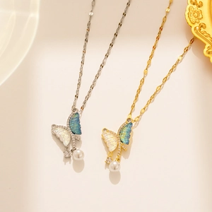 Detail of asymmetric butterfly necklaces in gold and silver with blue gradient inlay