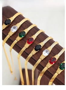 Detail of colorful oval gemstones and snake chain necklaces on dark wooden stand