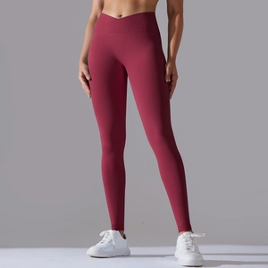Detail of high-waist crisscross ribbed waistband on dark red seamless yoga leggings