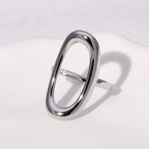 Minimalist silver geometric oval ring on a white ceramic tray with polished finish
