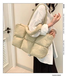 Detail of khaki quilted puffer tote bag showing padded texture and mesh stitching design