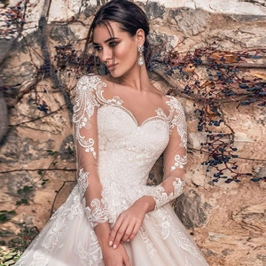 Detail of elegant white lace long sleeve wedding gown with intricate floral patterns