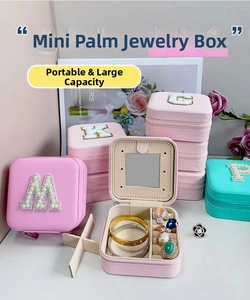 Detail view of mini portable jewelry box with mirror and letter decoration in mint and pink