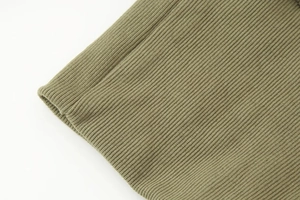 Vue macro de la texture en maille côtelée vert olive haute densité sur la manche de veste