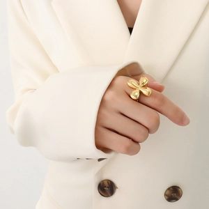 Fashionable 18K gold plated stainless steel chunky floral ring worn with a cream blazer