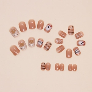 Detailed view of short square press-on nails with cartoon bear and letter art patterns