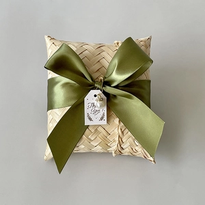 Detail of handmade bamboo gift box with olive green ribbon, pearl charm, and Thank You tag
