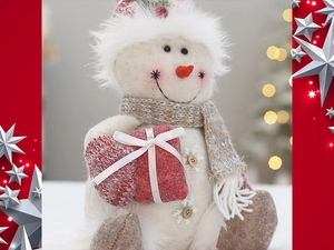Macro detail of Christmas snowman plush doll with knitted scarf and red heart ornament
