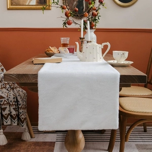 White faux fur Christmas table runner with long plush texture on dark wood table