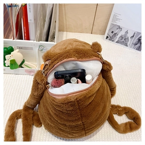 Detail of plush capybara backpack showing zipper opening and white lining storage space