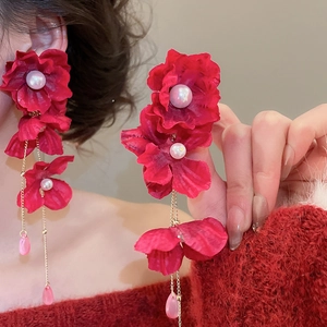 Detail of red fabric flower earrings with long gold tassels and crystal water drop charms