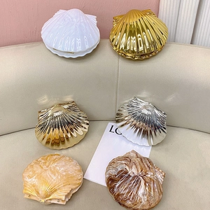 Selection of shell clutch bags with metallic, pearlescent, and marble textures
