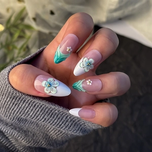 Macro shot of 3D embossed floral nail art with gold beads and green fluid marbling texture
