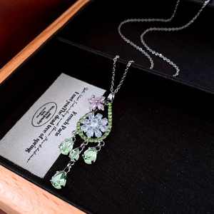 Gros plan détaillé du collier fleur en zircon avec pendentifs gouttes vertes en boîte à bijoux