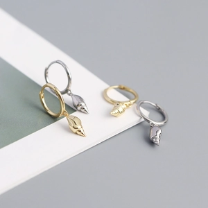 Detailed view of conch shell hoop earrings in gold and silver finish on display card