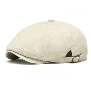 Side view of beige cotton newsboy hat with metal buckle detail and twill texture