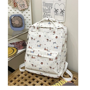 Detail of white canvas backpack featuring colorful cartoon dachshund dog print and zippers