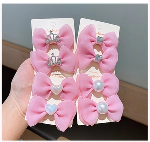Detailed set of eight pink tulle bow hair clips with crown and pearl embellishments