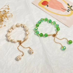 Detail view of crystal beaded bracelets with adjustable gold chain and marble texture beads