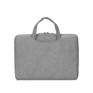 Close-up of a minimalist gray laptop sleeve with reinforced handles and durable fabric texture
