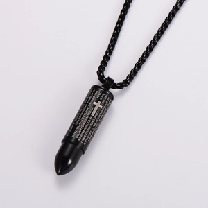 Close-up of black stainless steel bullet pendant with engraved Spanish scriptures and cross