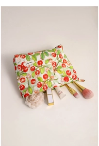 Detalle de neceser de lona con estampado de cerezas, cremallera duradera y etiqueta de marca