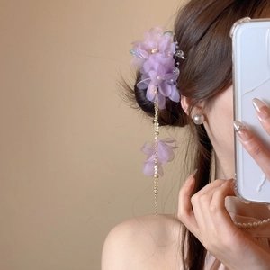 Détail d'une pince à cheveux fleur mauve avec pampilles de perles et chaîne dorée