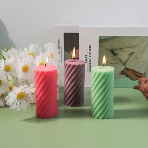 Detailed view of spiral cylinder silicone candle molds showing lit textured wax candles