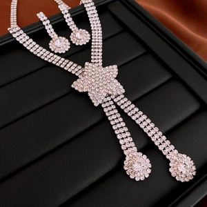 Detailed view of silver star and floral necklace set with sparkling rhinestones on black tray