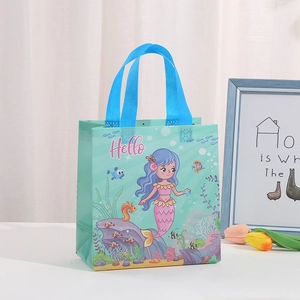 Detailed view of mermaid party gift bag with teal handle and cartoon princess print