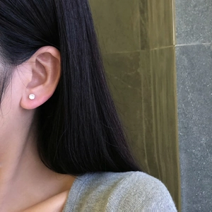 Close-up of a 925 sterling silver stud earring with a 5A zircon on a model ear